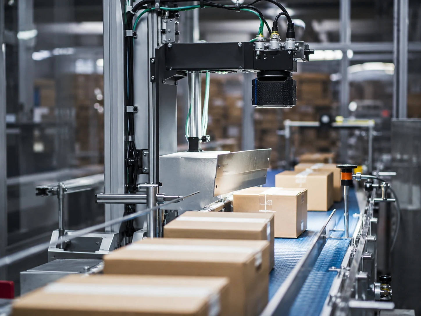 Real logistics conveyor with fixed barcode reader scanning cartons
