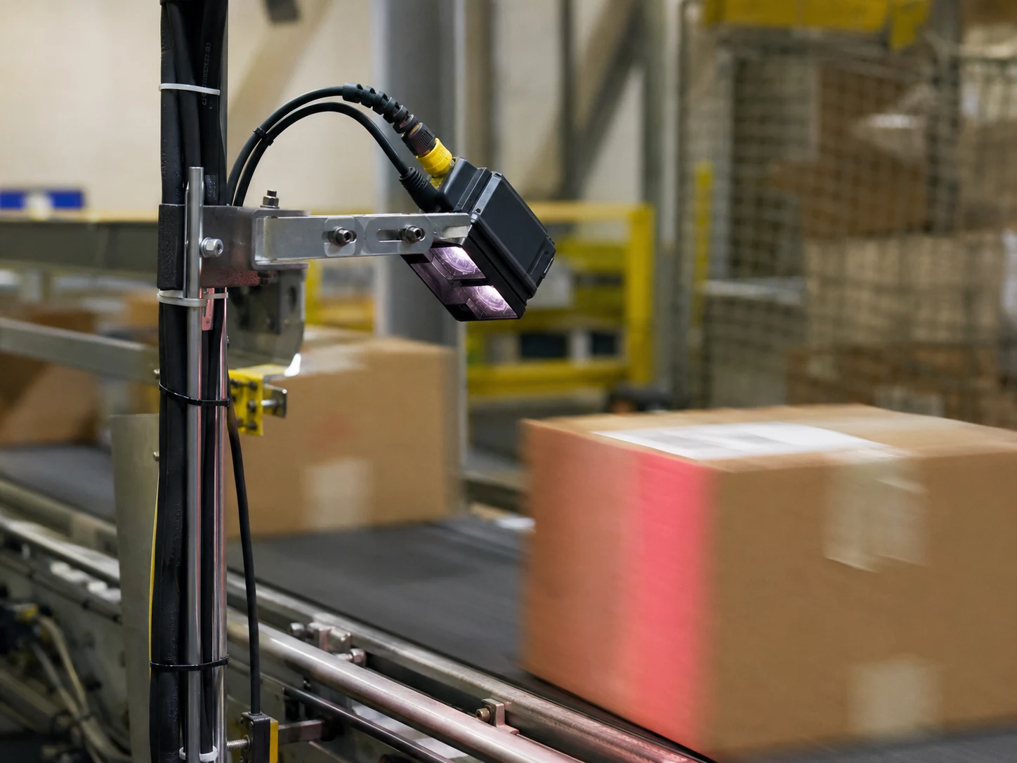 Real fixed barcode reader scanning cartons on a conveyor